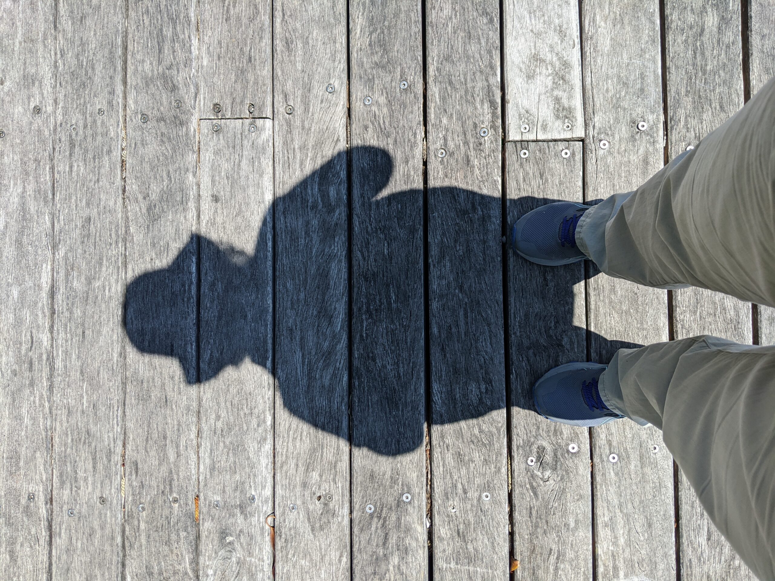 my midday shadow on an old wooden pier